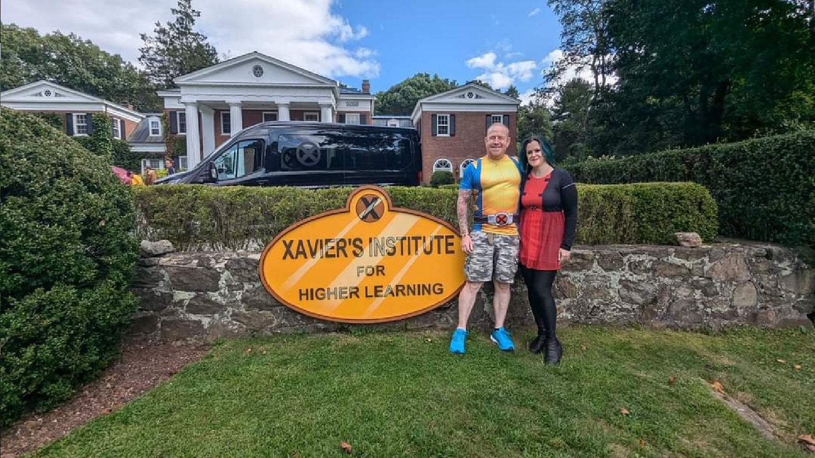 Ellie & Simon Rice in front of a Xavier Institue sign